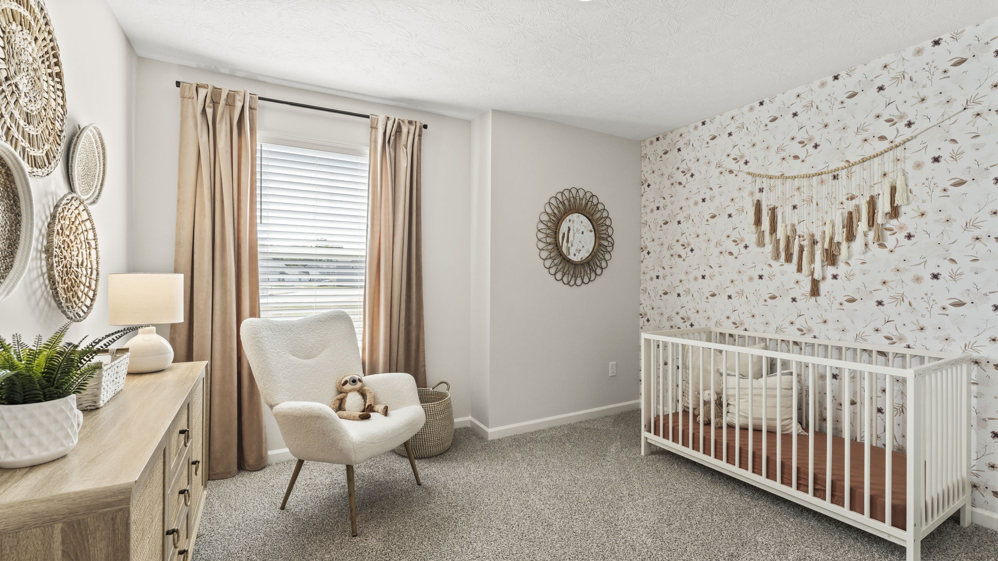 Bedroom configured as a nursery with wallpaper, crib, and soothing decorations