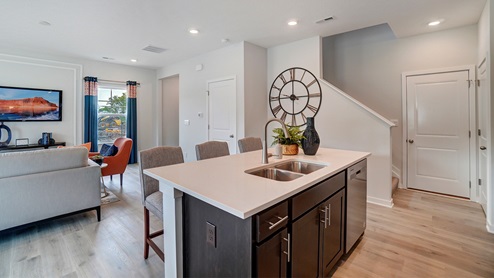 Kitchen Island in full with view of stairs going upstairs.