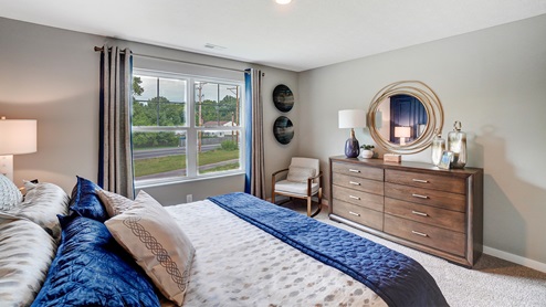 Primary bedroom with wooden décor with large king bed.