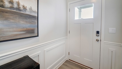 Foyer showing wooden welcome desk and white door with glass window