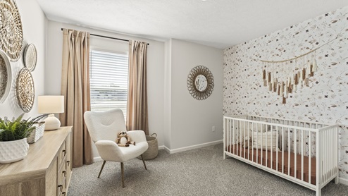 Bedroom configured as a nursery with wallpaper, crib, and soothing decorations