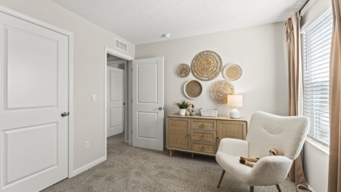 Bedroom with view of cabinets, art, and chair