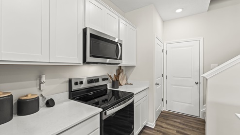 Side view of white counter with appliances, echo dot, and cutting boards