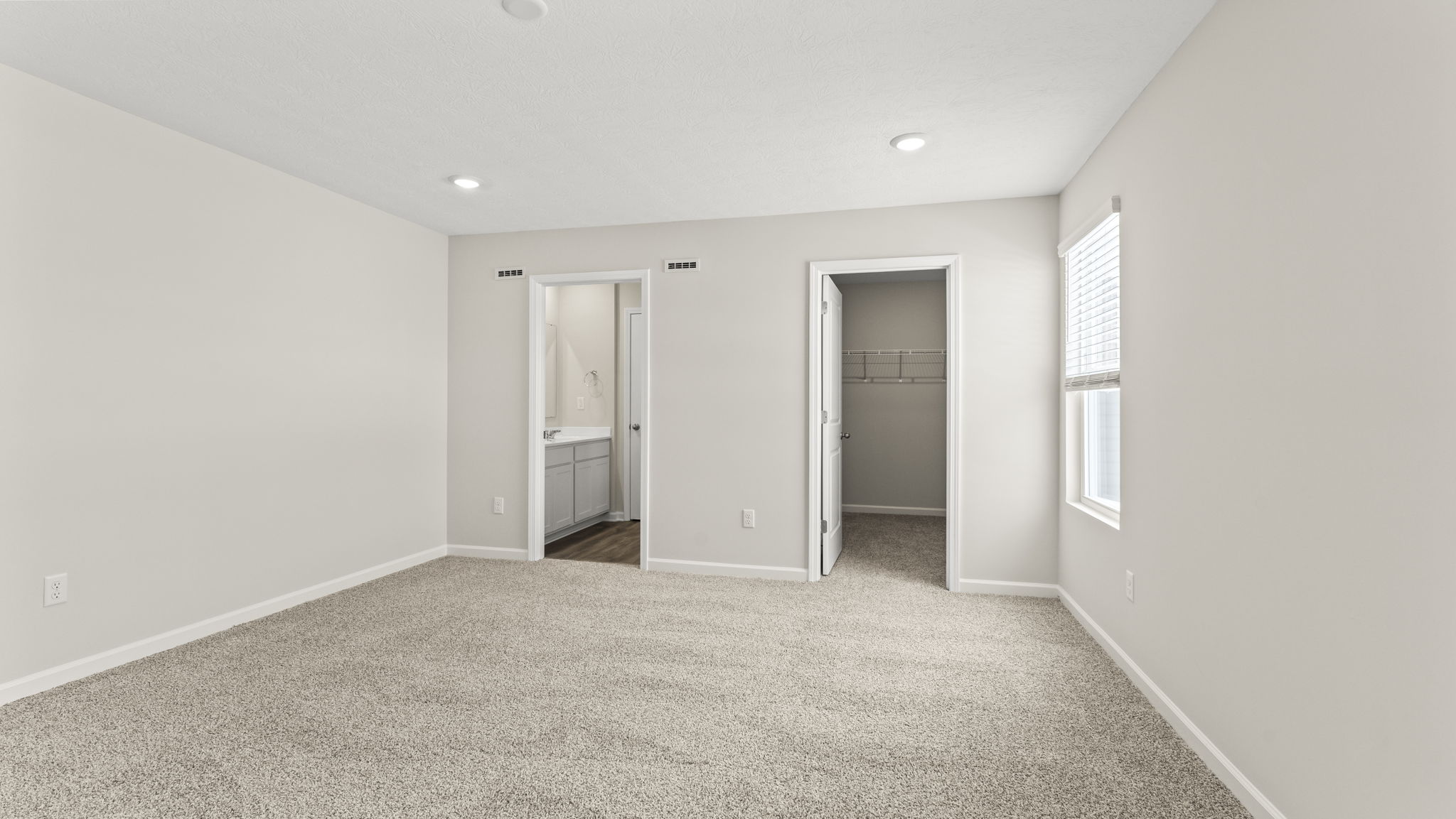 Primary bedroom looking into primary bathroom