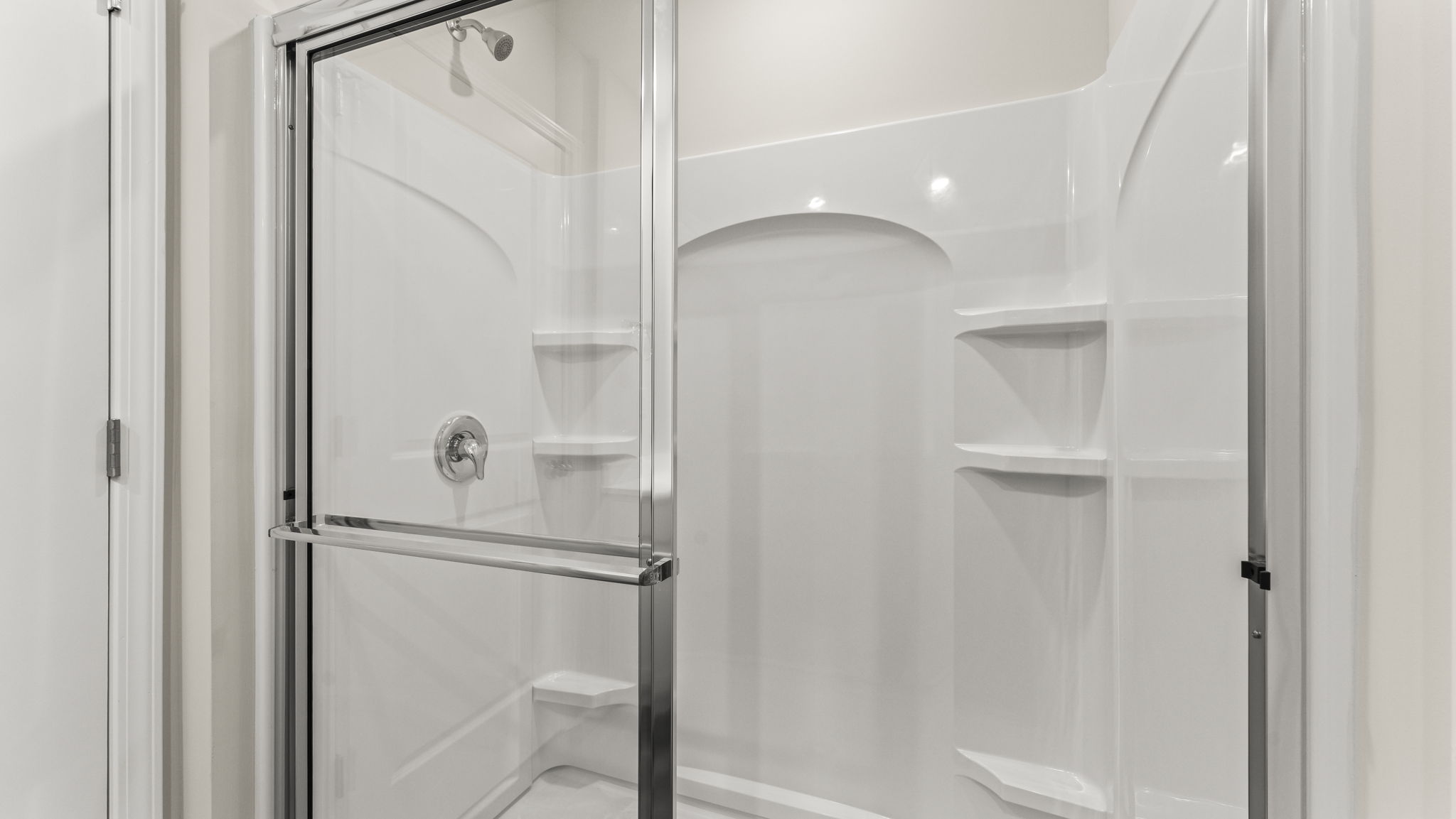 Closeup of walk-in shower with tiered shelving