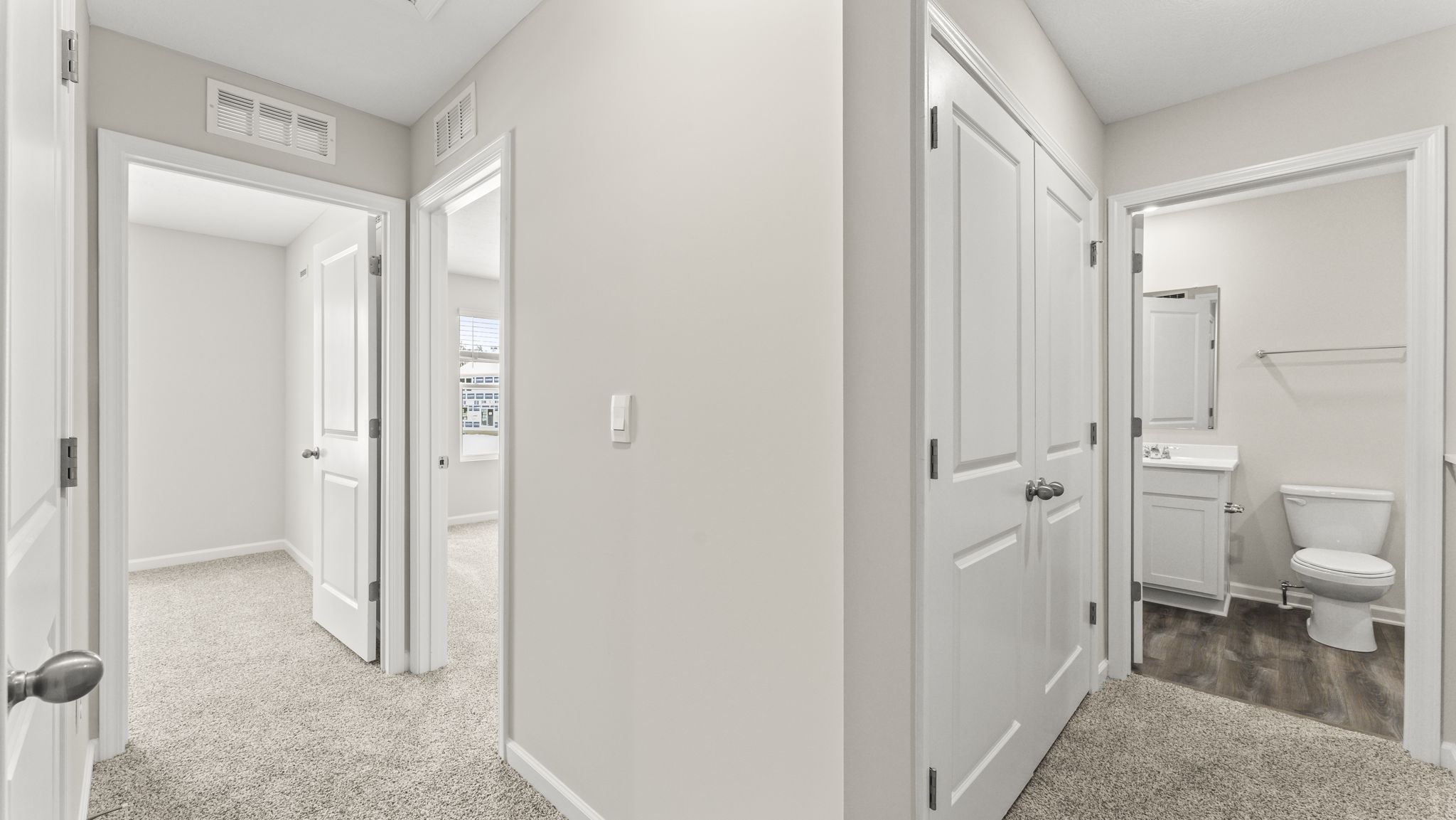 Upstairs hallway with two bedrooms on the left of the frame and bathroom on the right