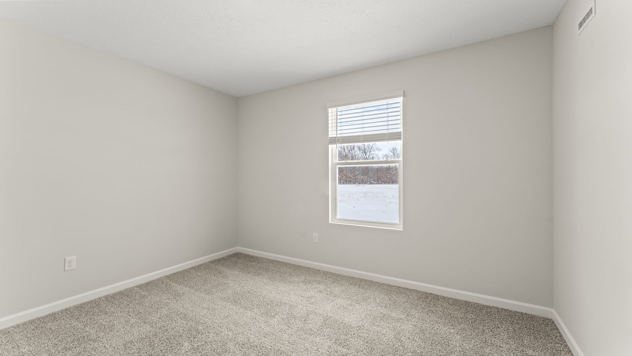 Bedroom with two outlets in frame, window, and carpet.