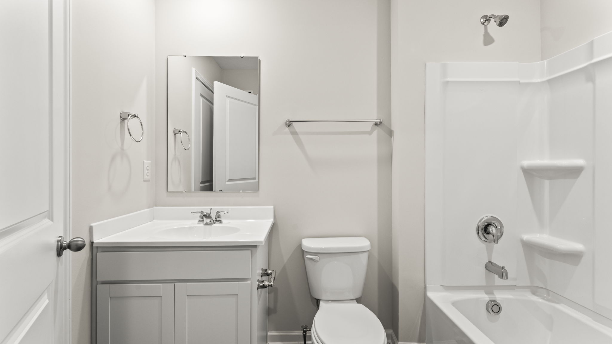 Bathroom with sink, mirror, toilet, and tub.