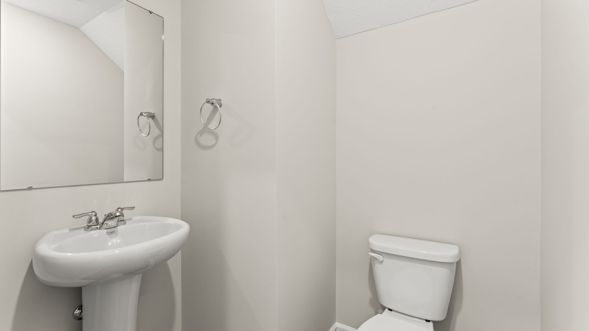 Powder room with sink, mirror, and toilet