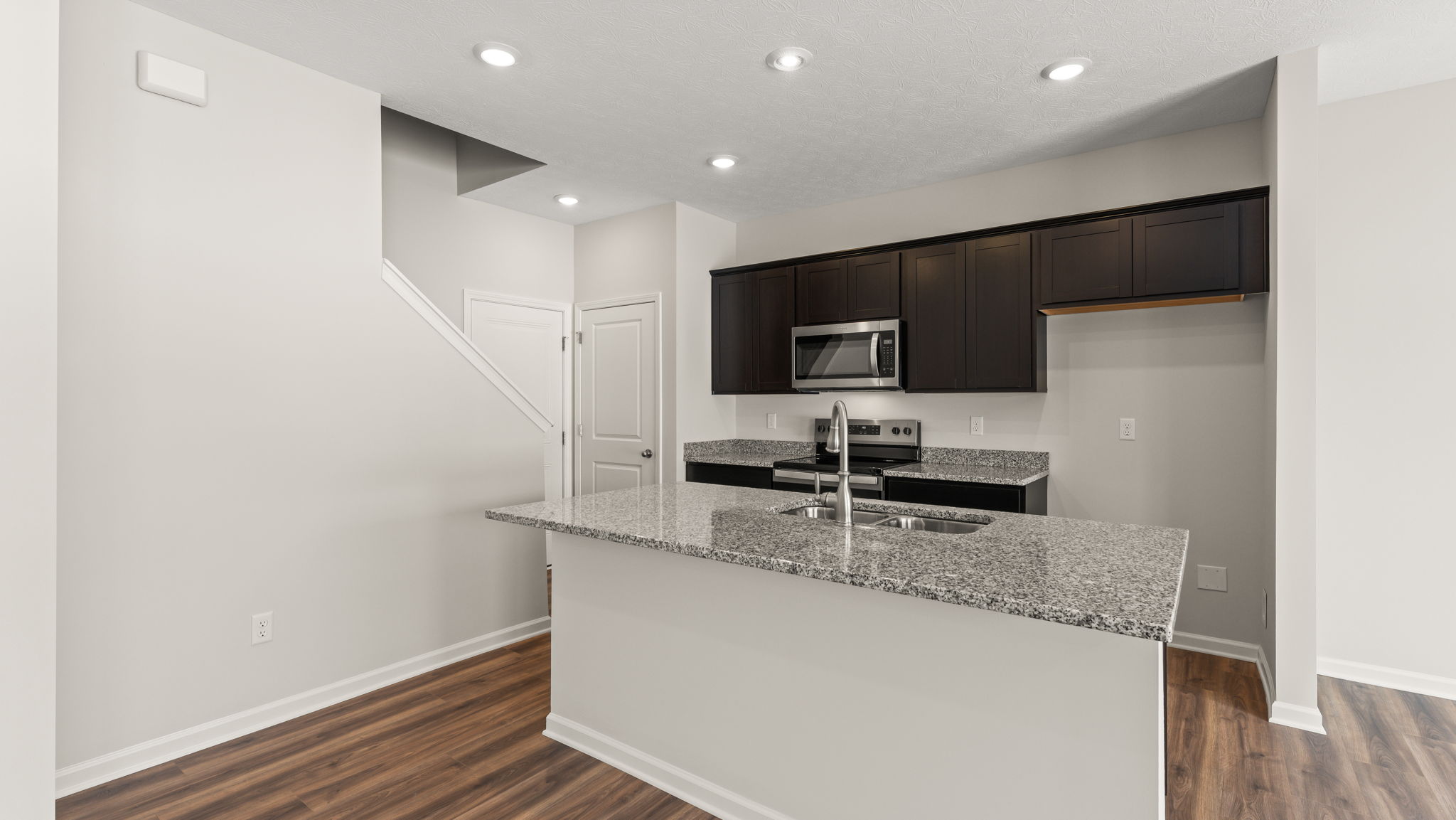 Three-quarter view of kitchen with brown cabinetry