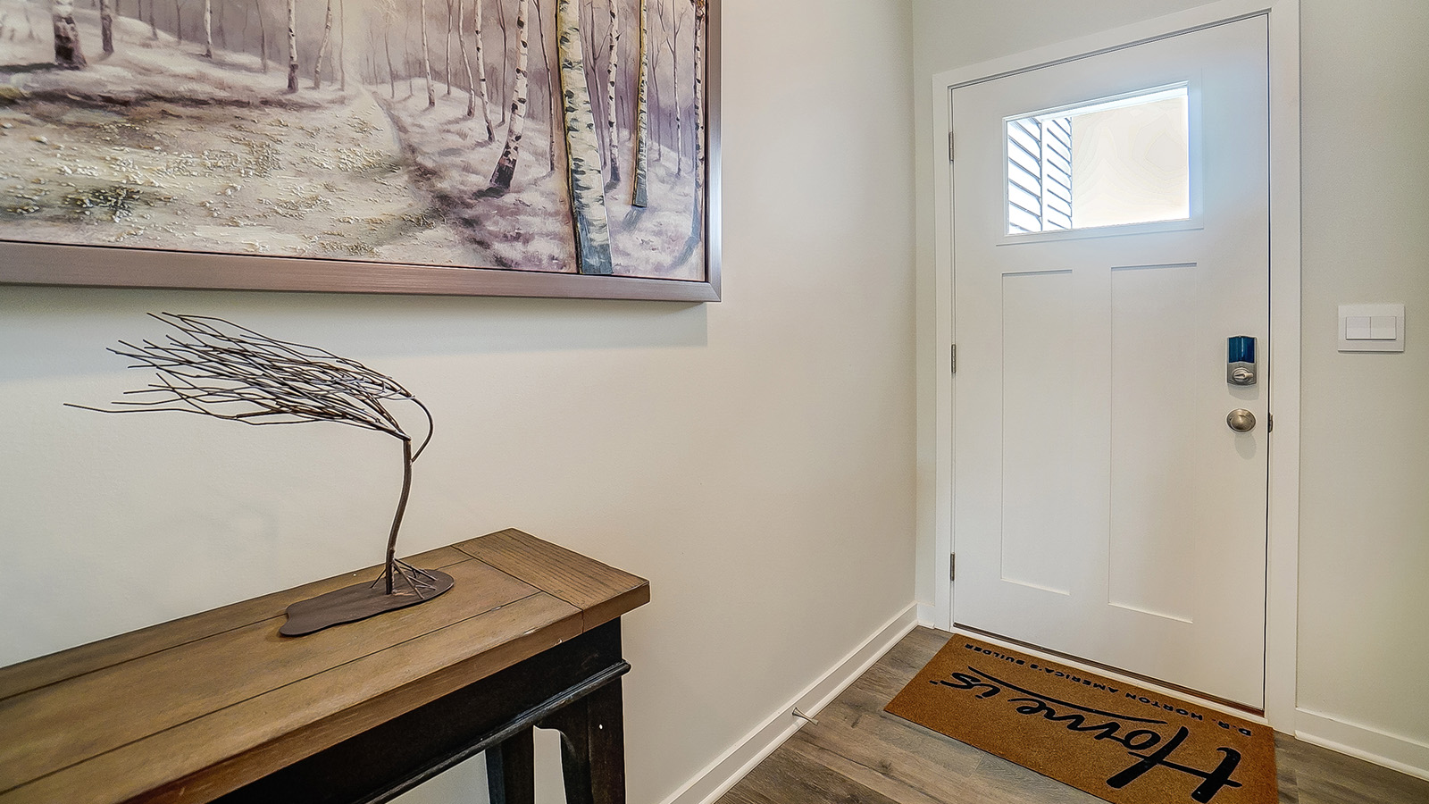 Foyer showing wooden wlcome desk and white door with glass window