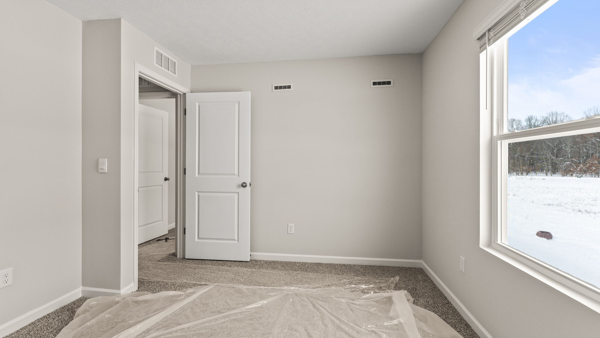 Carpeted bedroom with door to hallway