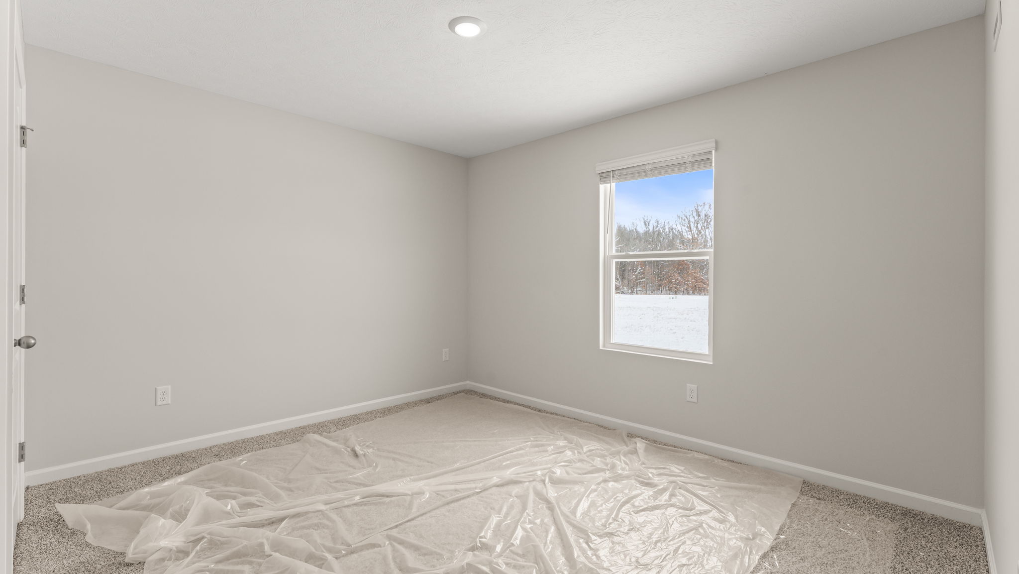 Carpeted bedroom with three outlets and window