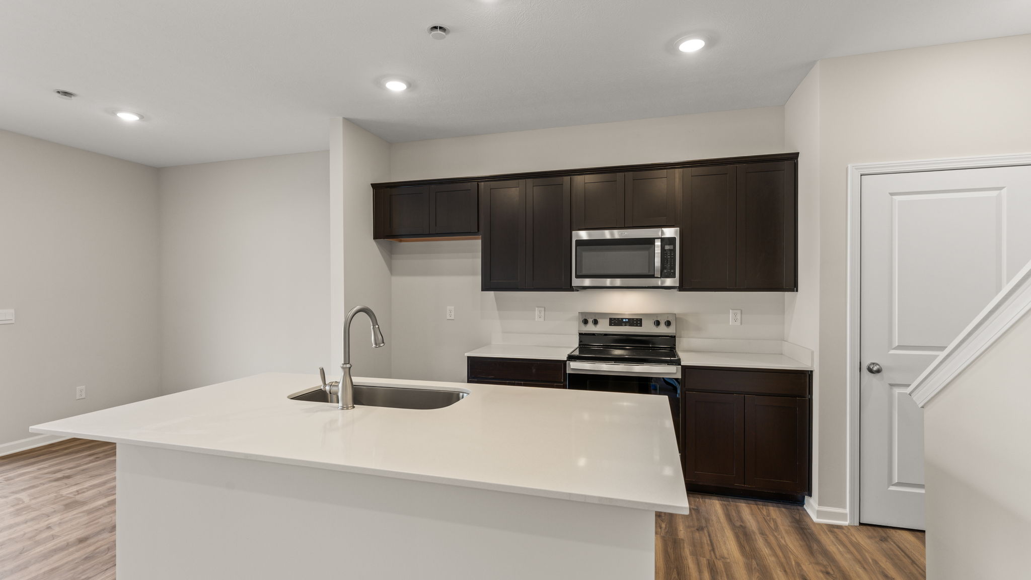 Kitchen with island, appliances, and brown cabinetry