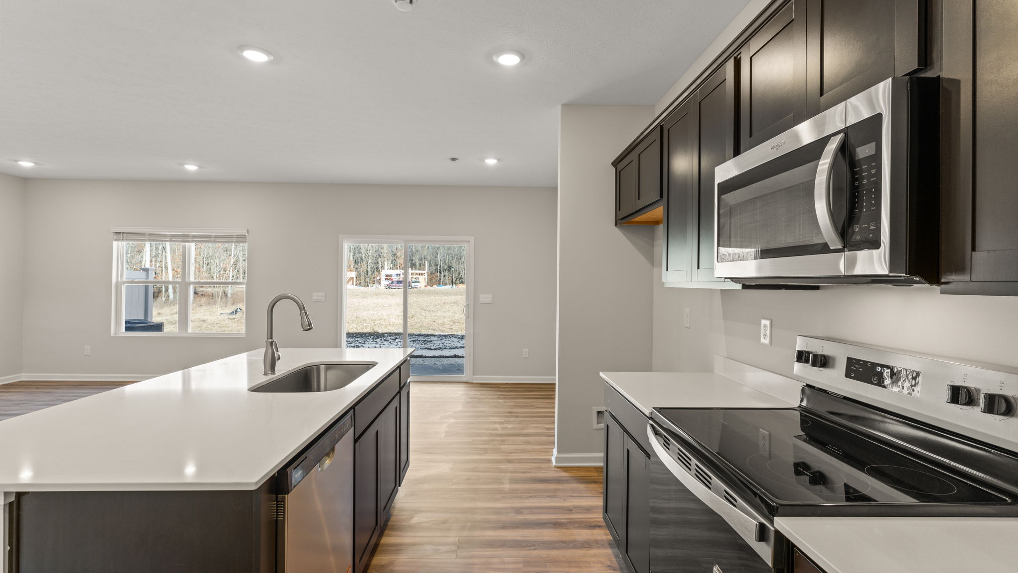 Side view of kitchen with island on the left and appliances on the right.