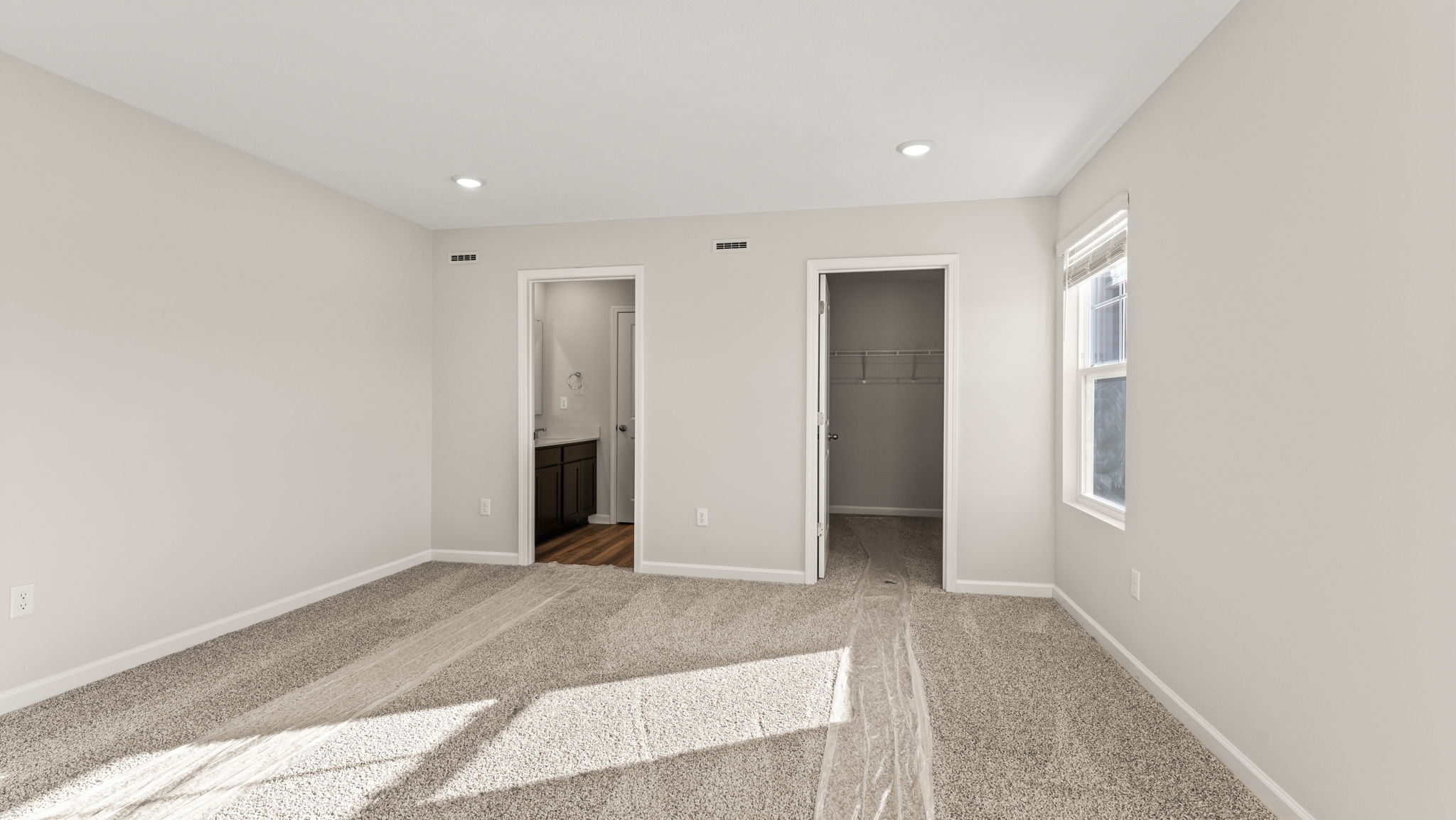 Primary bedroom with view of doors into bathroom and hallway