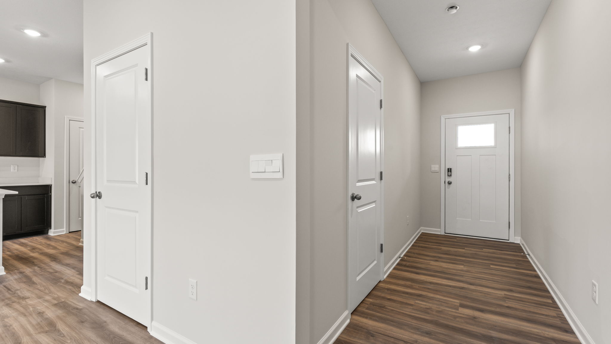 Foyer with kitchen on the left and door on the right.