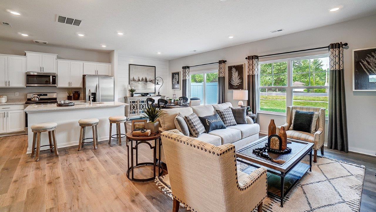 Great room in full with moder decorations and white cabinets.