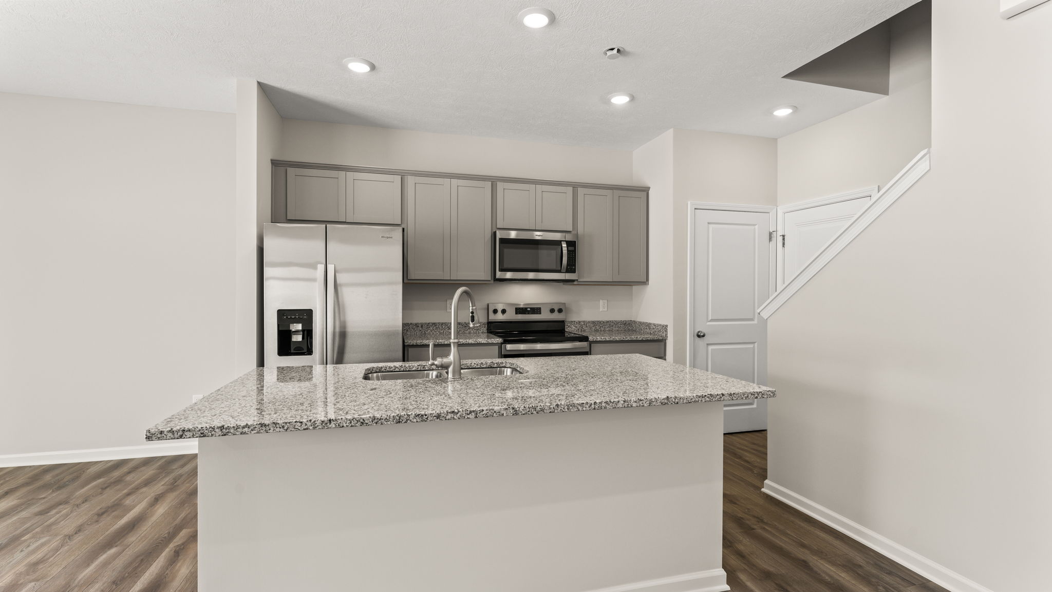 Straight-on shot of the kitchen with granite countertops.