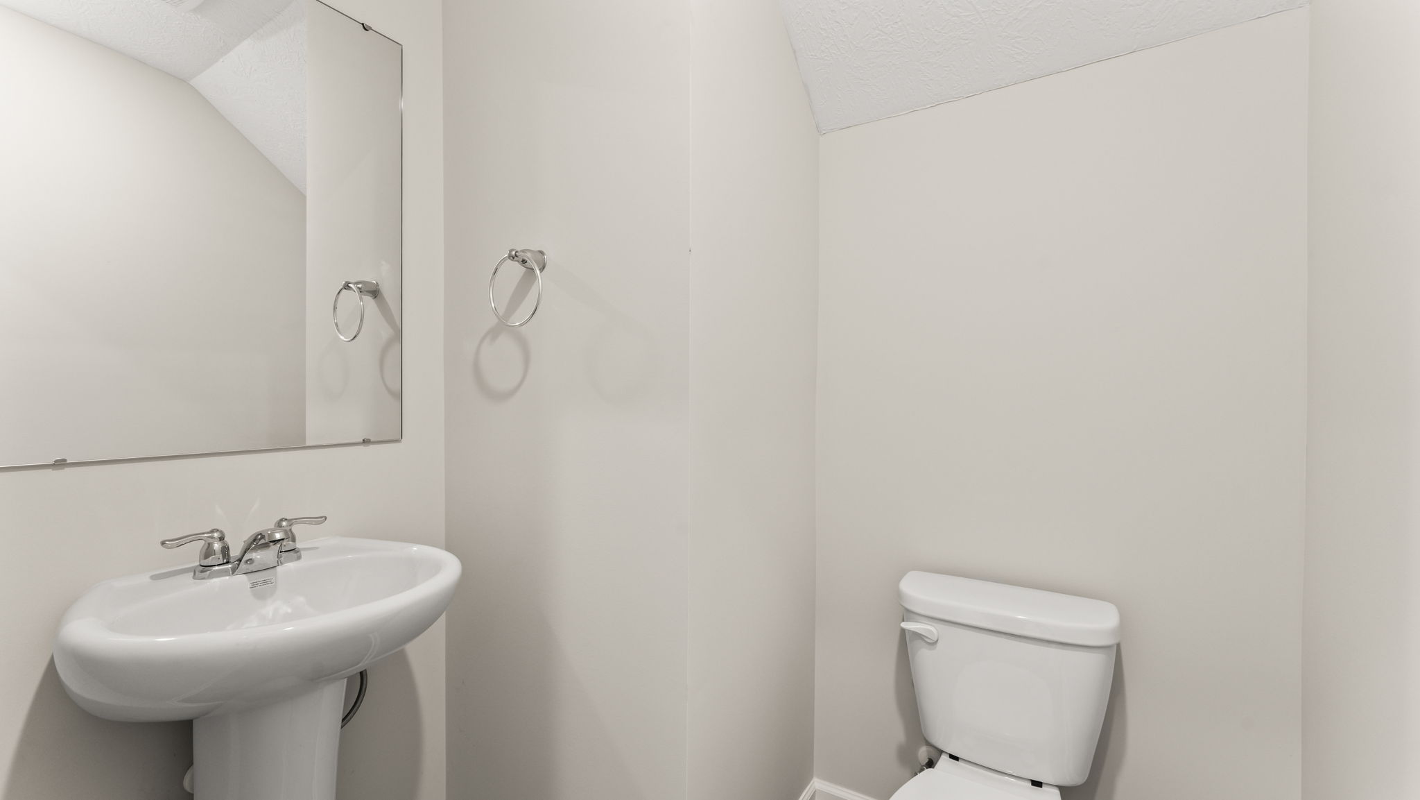Powder room with sink, mirror, and toilet