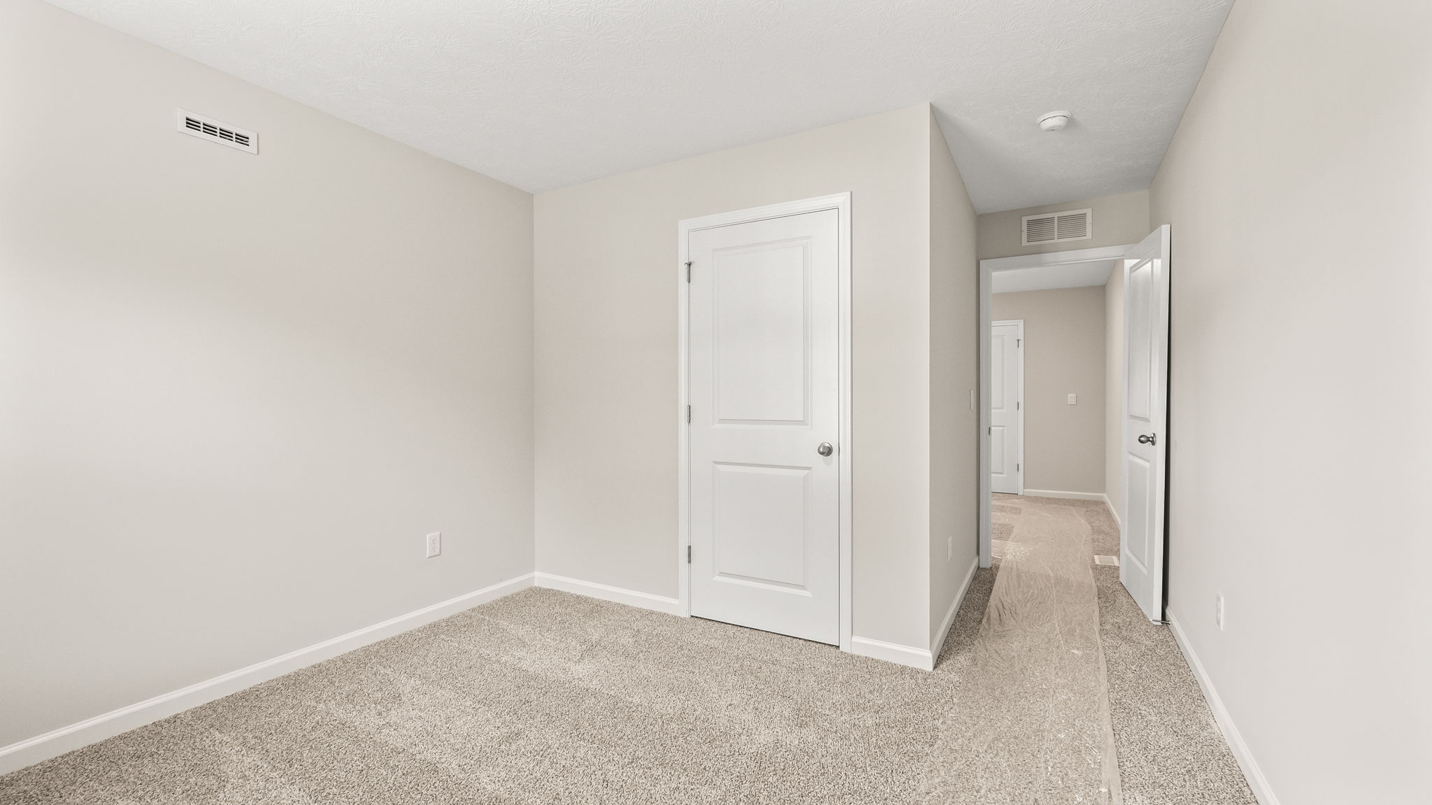 Carpeted bedroom with closet