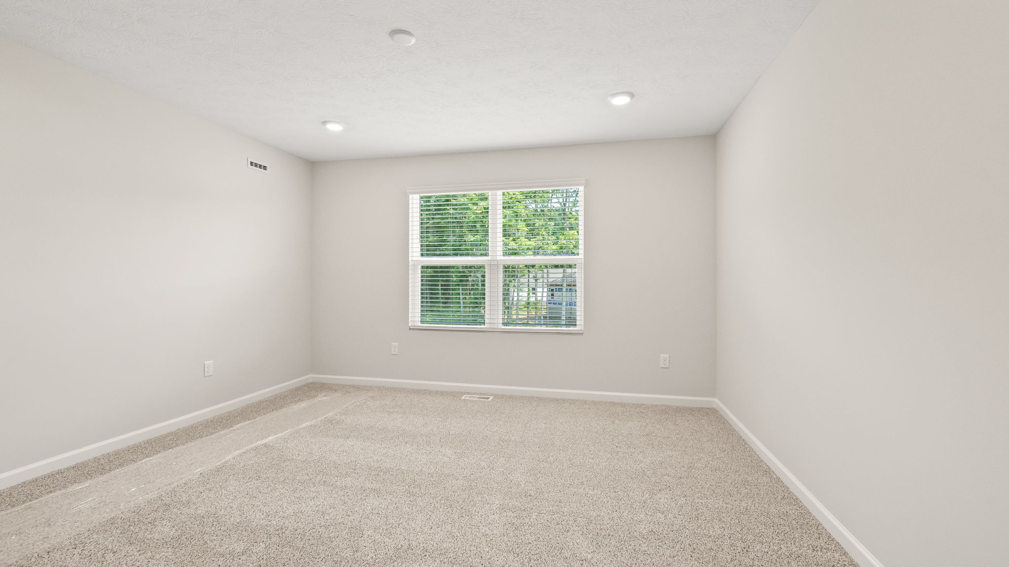 Carpeted primary bedroom with window