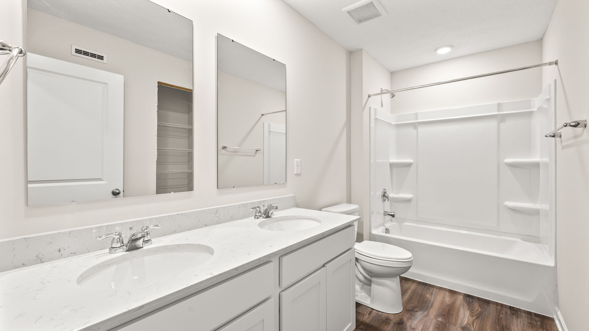 Bathroom with double sink and mirror with toilet and tub