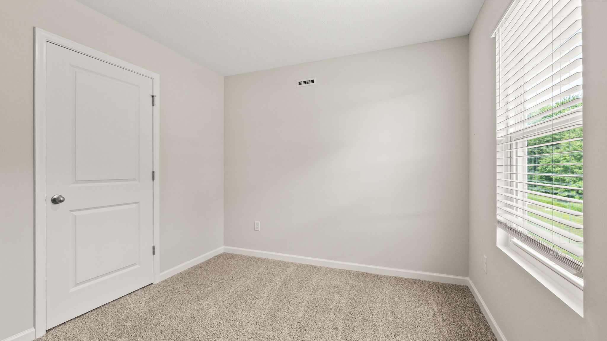 Carpeted bedroom with window and closet door