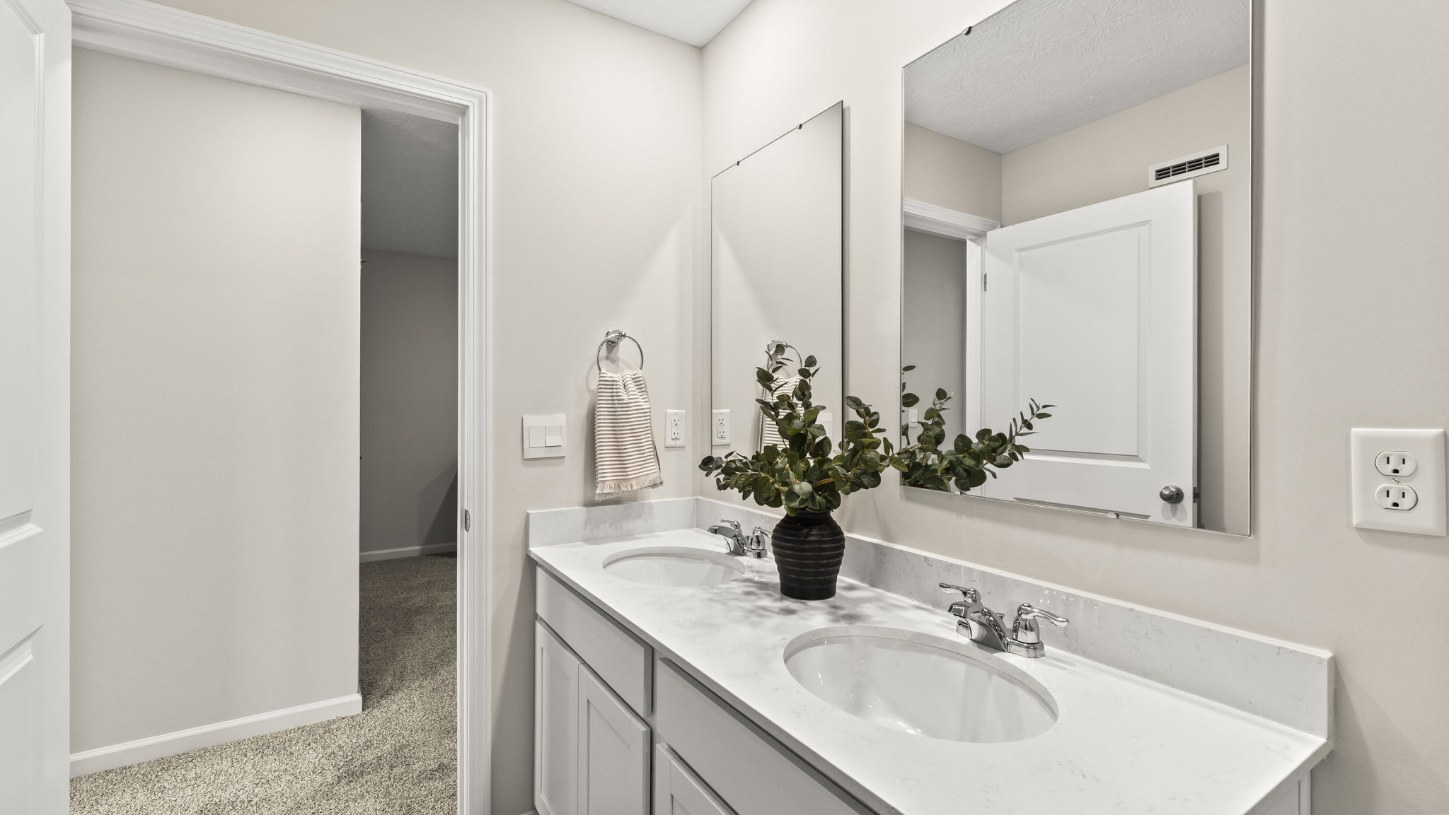 Upstairs bathroom with dual vanity sink and mirrors