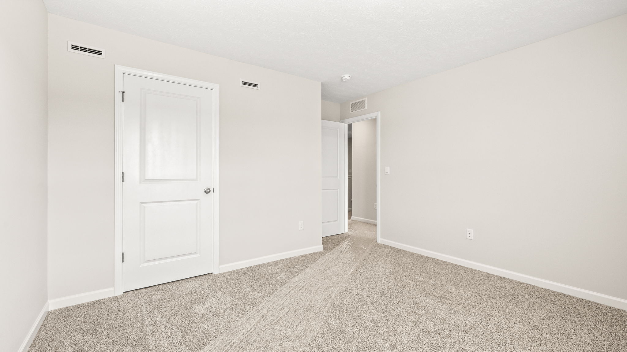Carpeted bedroom with closet door