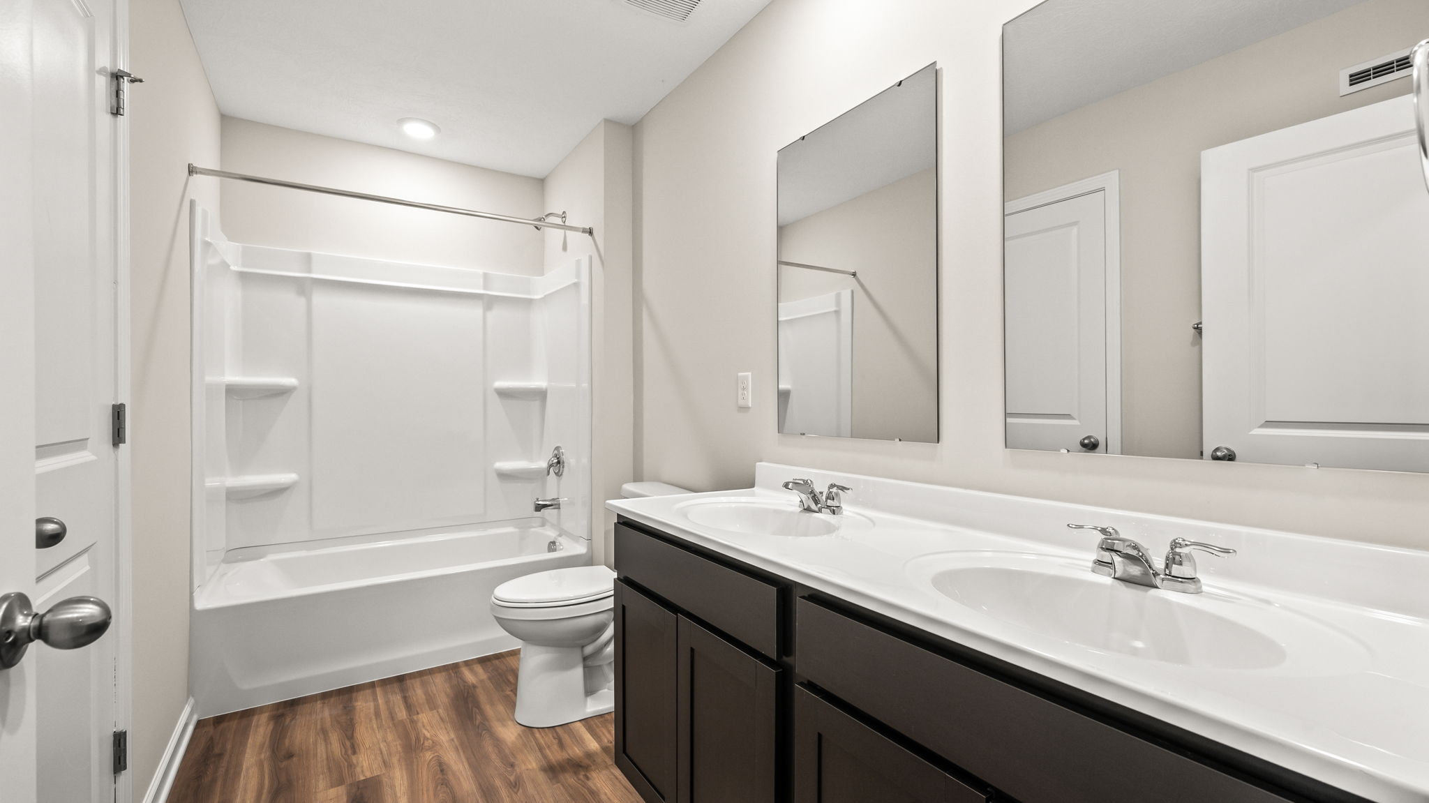 Bathroom with toilet, tub, and double bowl sink
