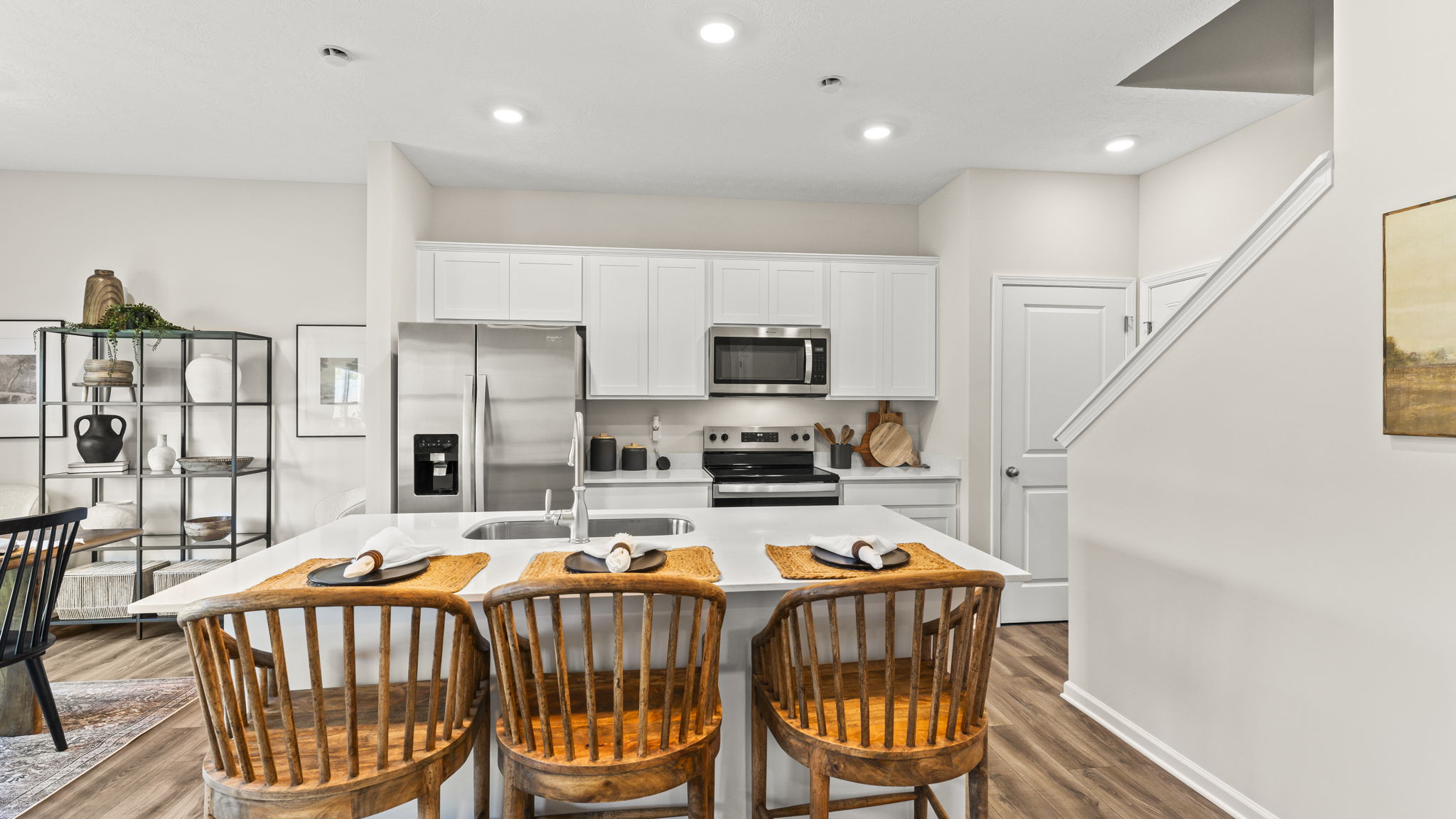 Kitchen island view of kitchen with white cabinetry and appliances