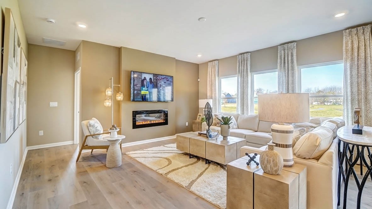 Open concept living room with gorgeous fireplace and large windows
