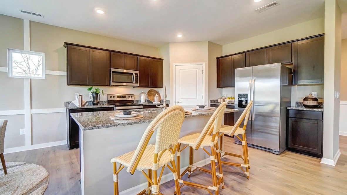Large kitchen with granite countertops and brown cabinets and appliances