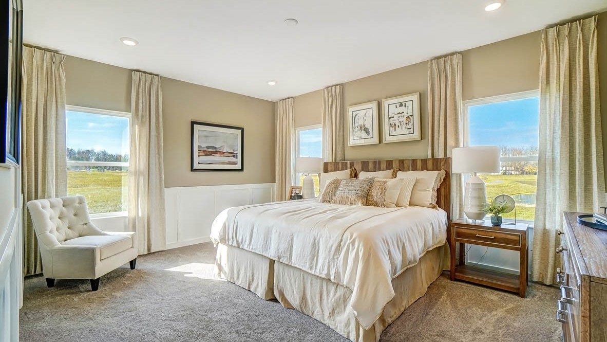 Primary Bedroom with large bed, modern art, and 3 large windows with decorative décor.