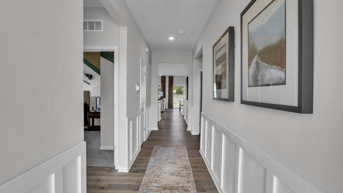 front foyer hallway leading into great room decorated with modern art.