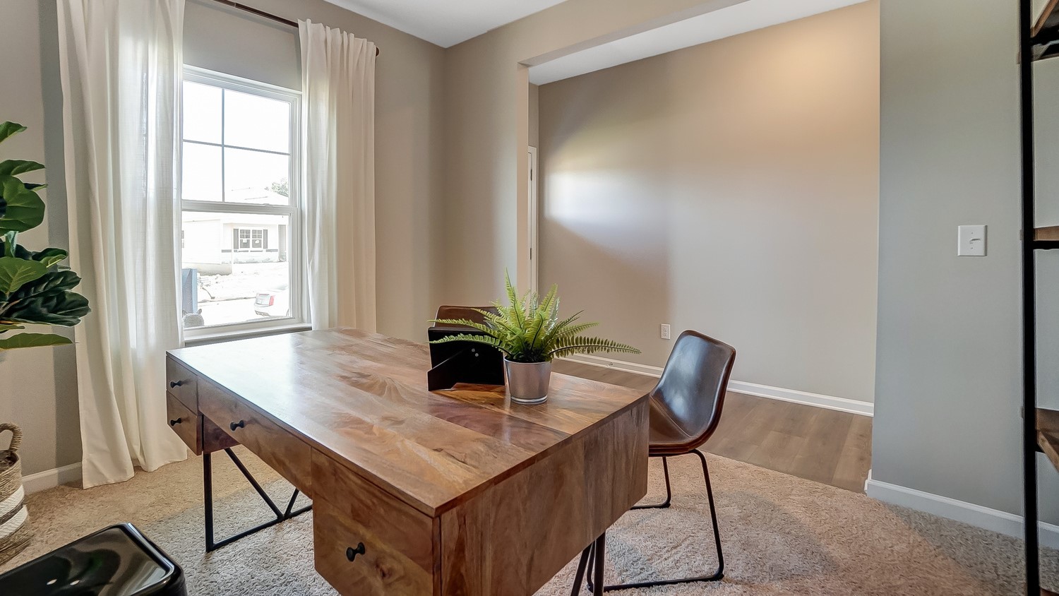 Office with beautiful wooden desk and foyer in the background.