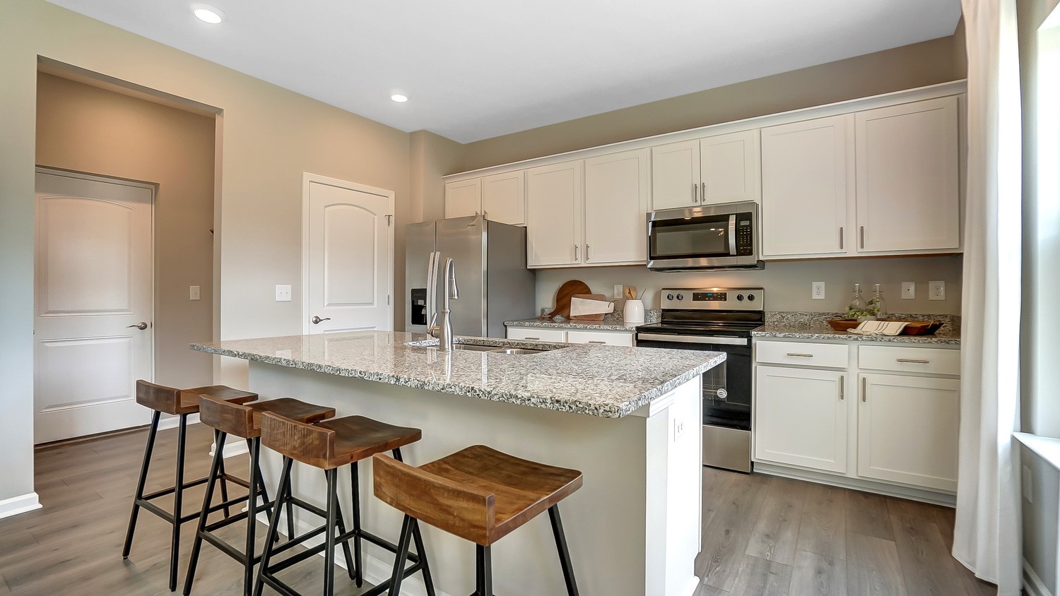 Window view of kitchen with stainless steel appliances, granite countertops.