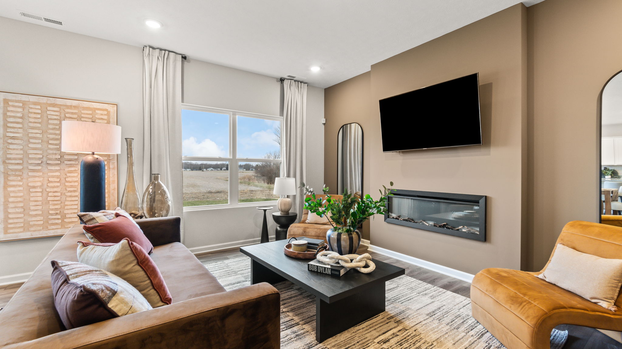 Closeup of living room couch, coffee table, tv, and electric fireplace.