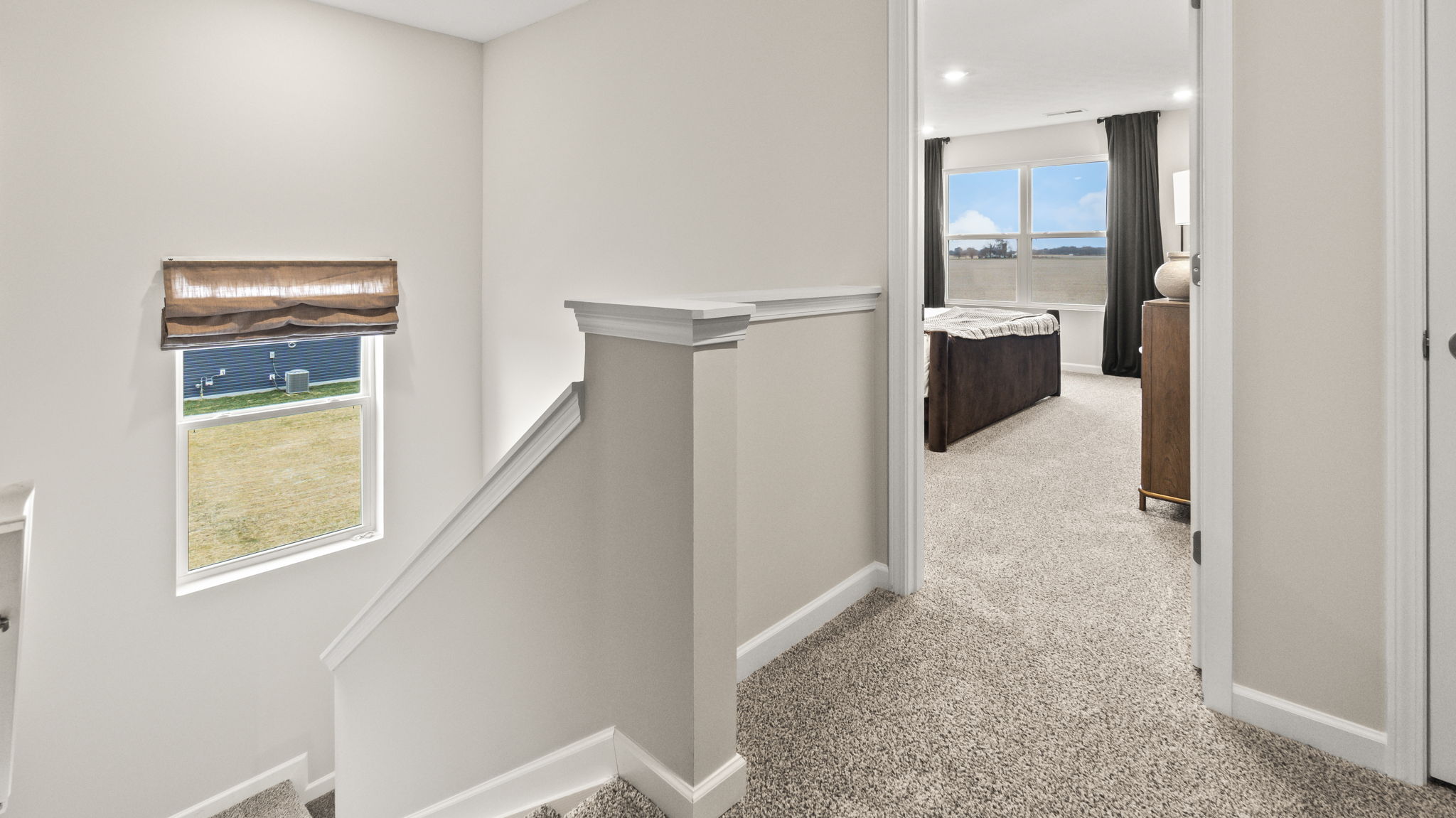 Upstairs landing leading downstairs and the primary bedroom on the right.