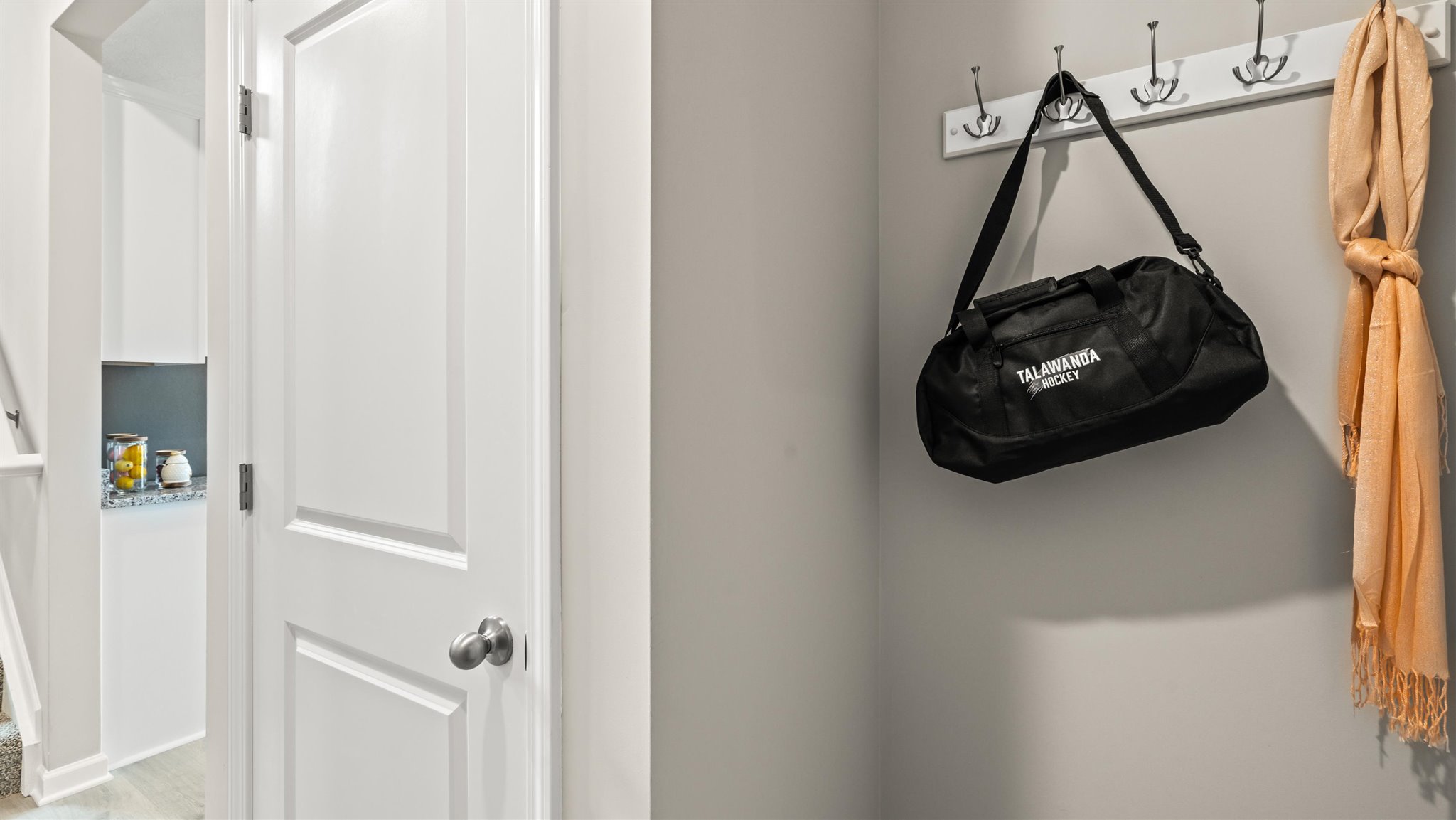 hangers in mud room with storage closet door.