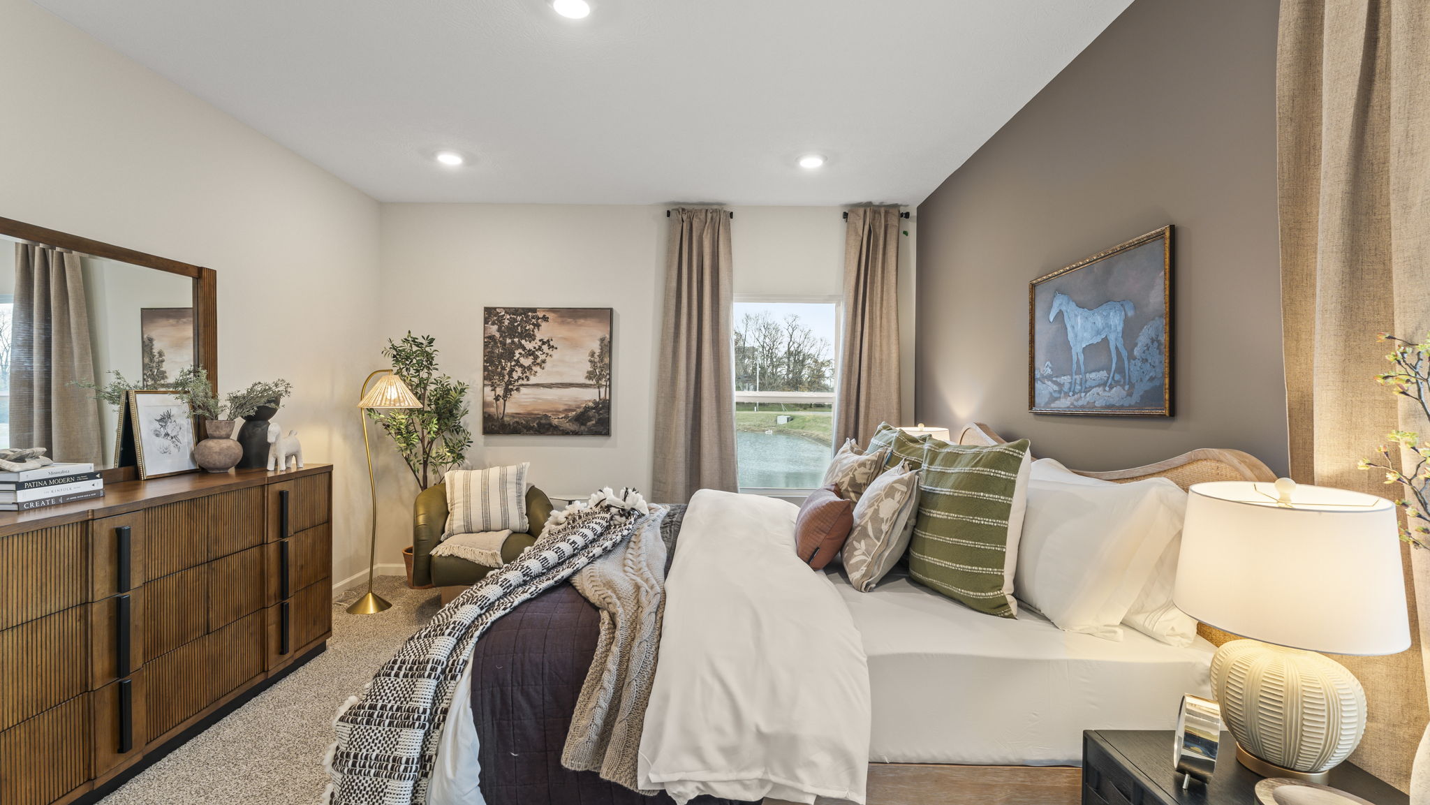 Side view of primary bedroom with view of pond in window.