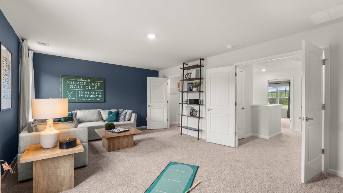 Second family room with sectional couch in corner and shelf