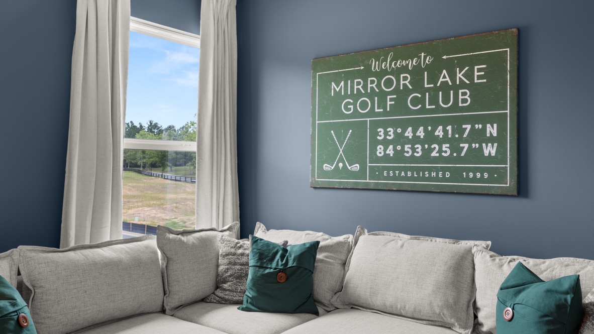 Closeup of couch in front of blue painted wall that has a golf club plaque on it