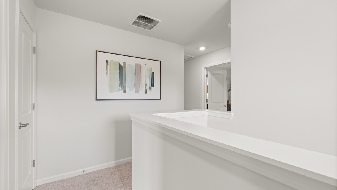 upstairs landing with white walls and abstract picture hanging