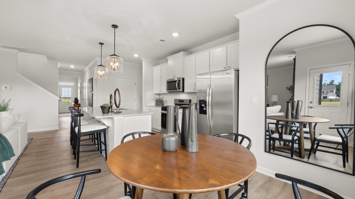 Closeup of dining table with tall silver pitchers as table dressing