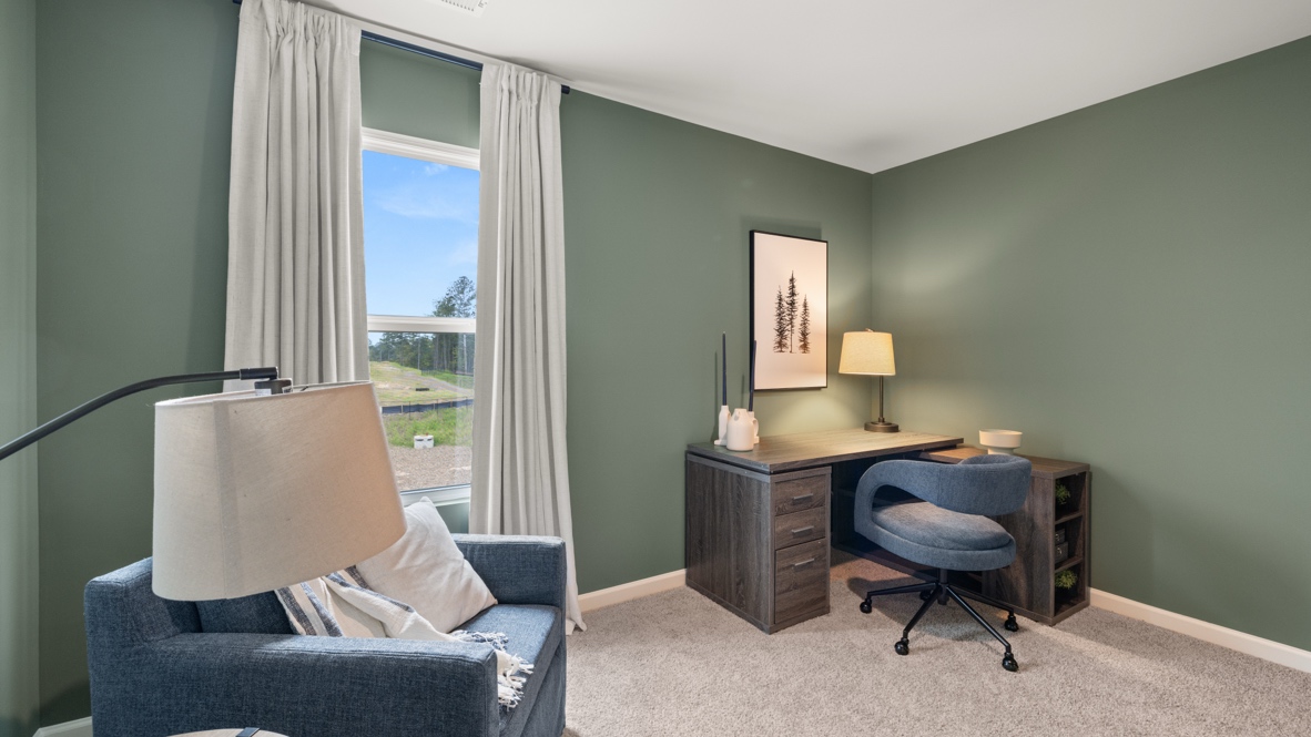 Office space with lamp, wooden desk, and blue chairs.