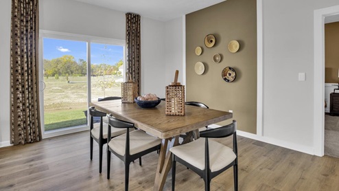 dining room table with modern art and large sliding door to back yard patio.