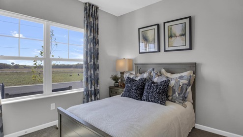large wide windows with modern art and bed.