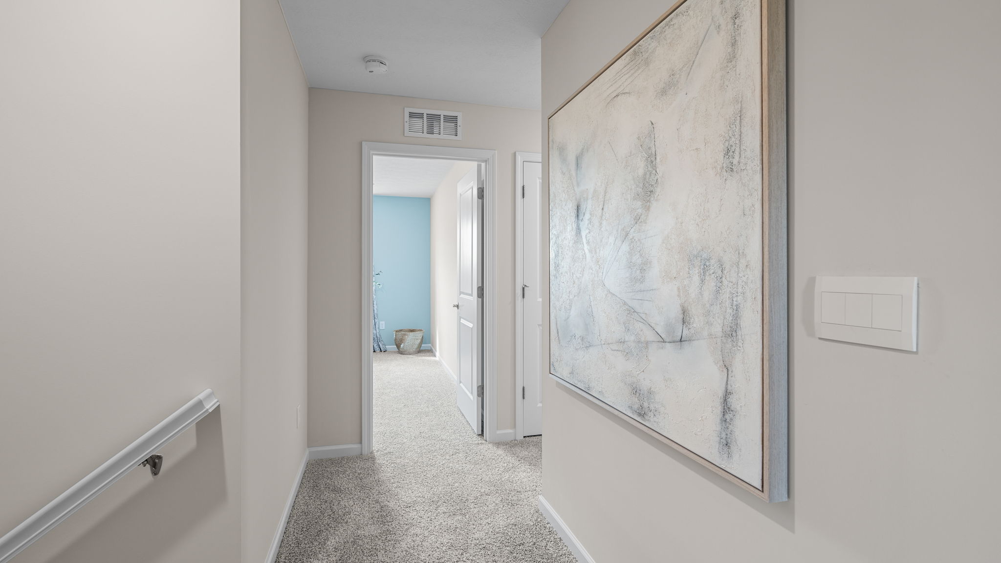 Upstairs carpeted hallway near bedrooms.